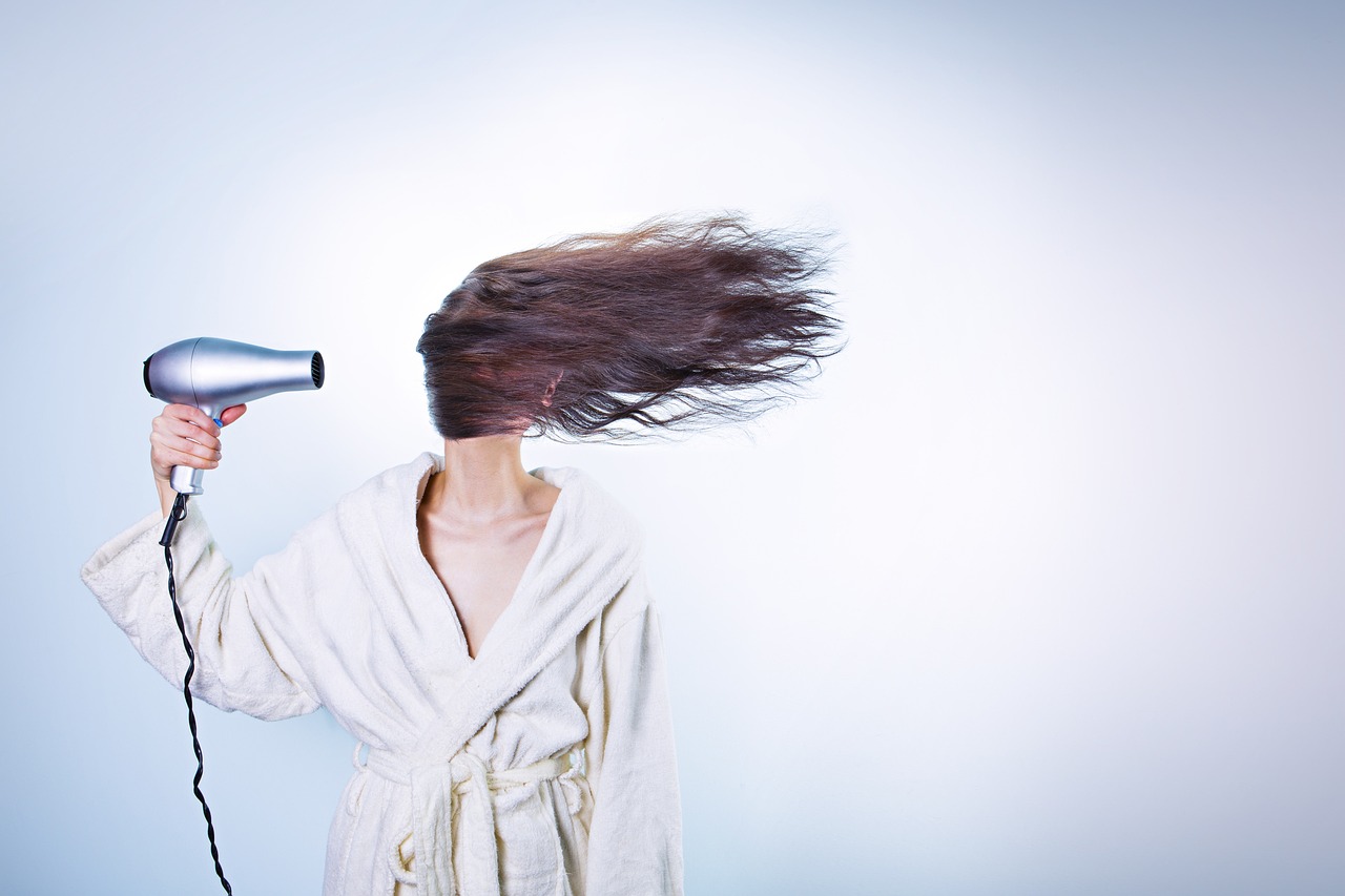 Capelli danneggiati da un phon usato in modo scorretto, evidenziando l'importanza di una corretta asciugatura.